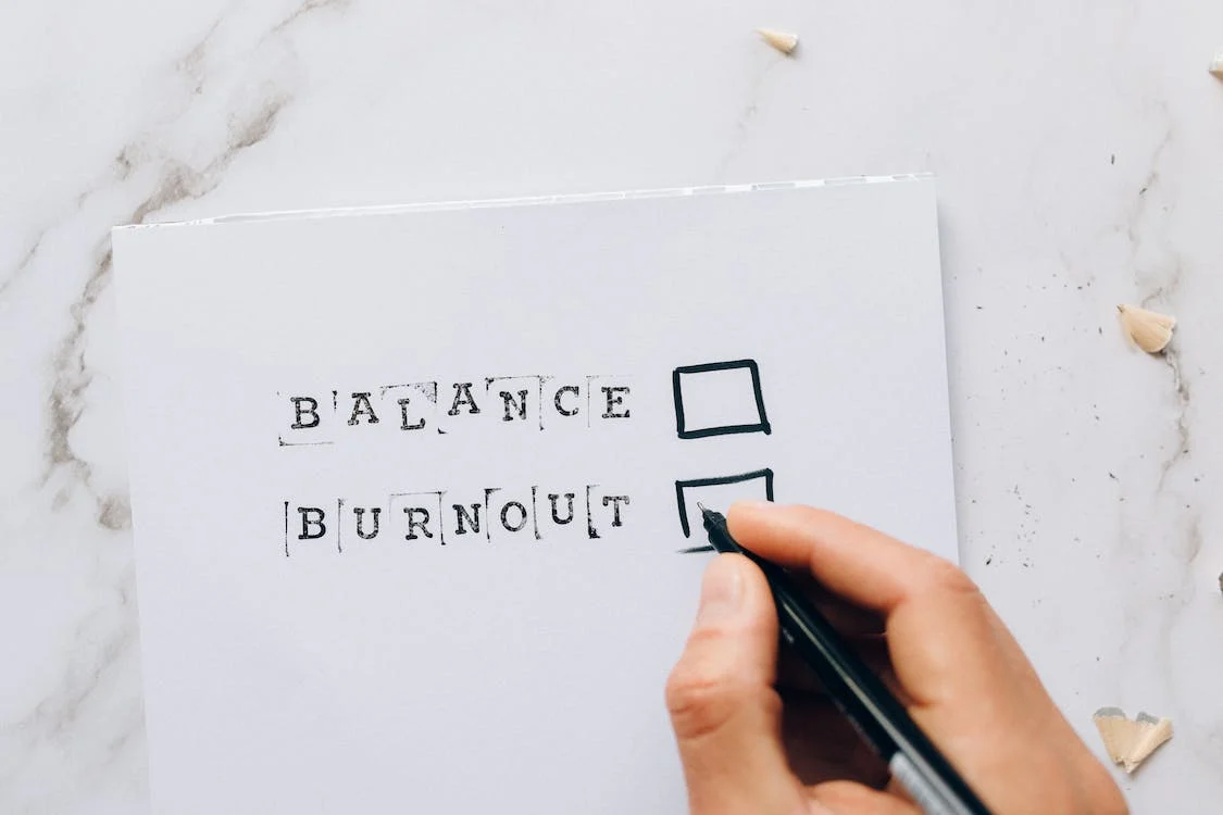 balance burnout checkbox with hand holding pen
