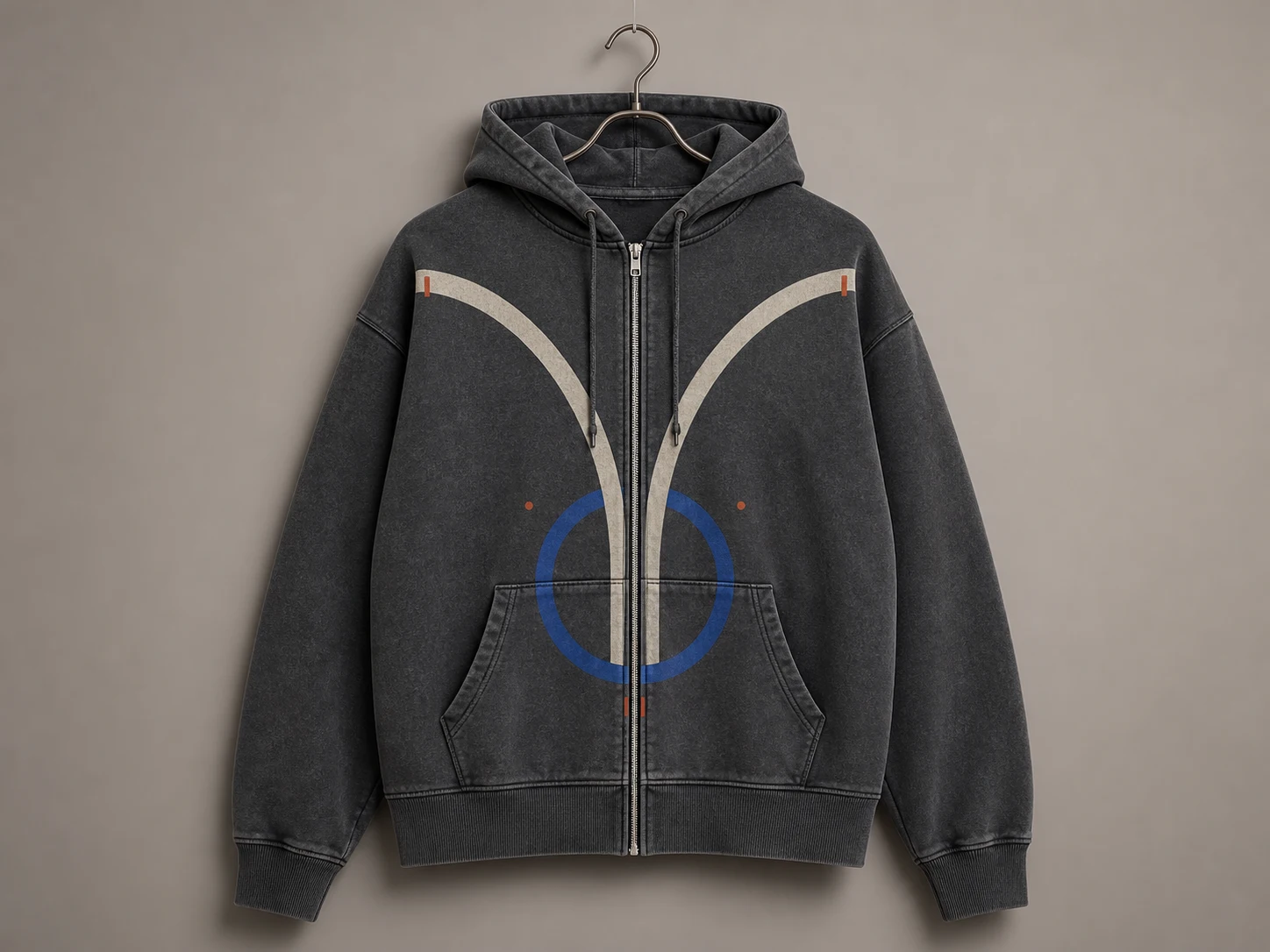 Gray hoodie with abstract geometric design featuring arcs and circles, hanging on a hook against a plain background.