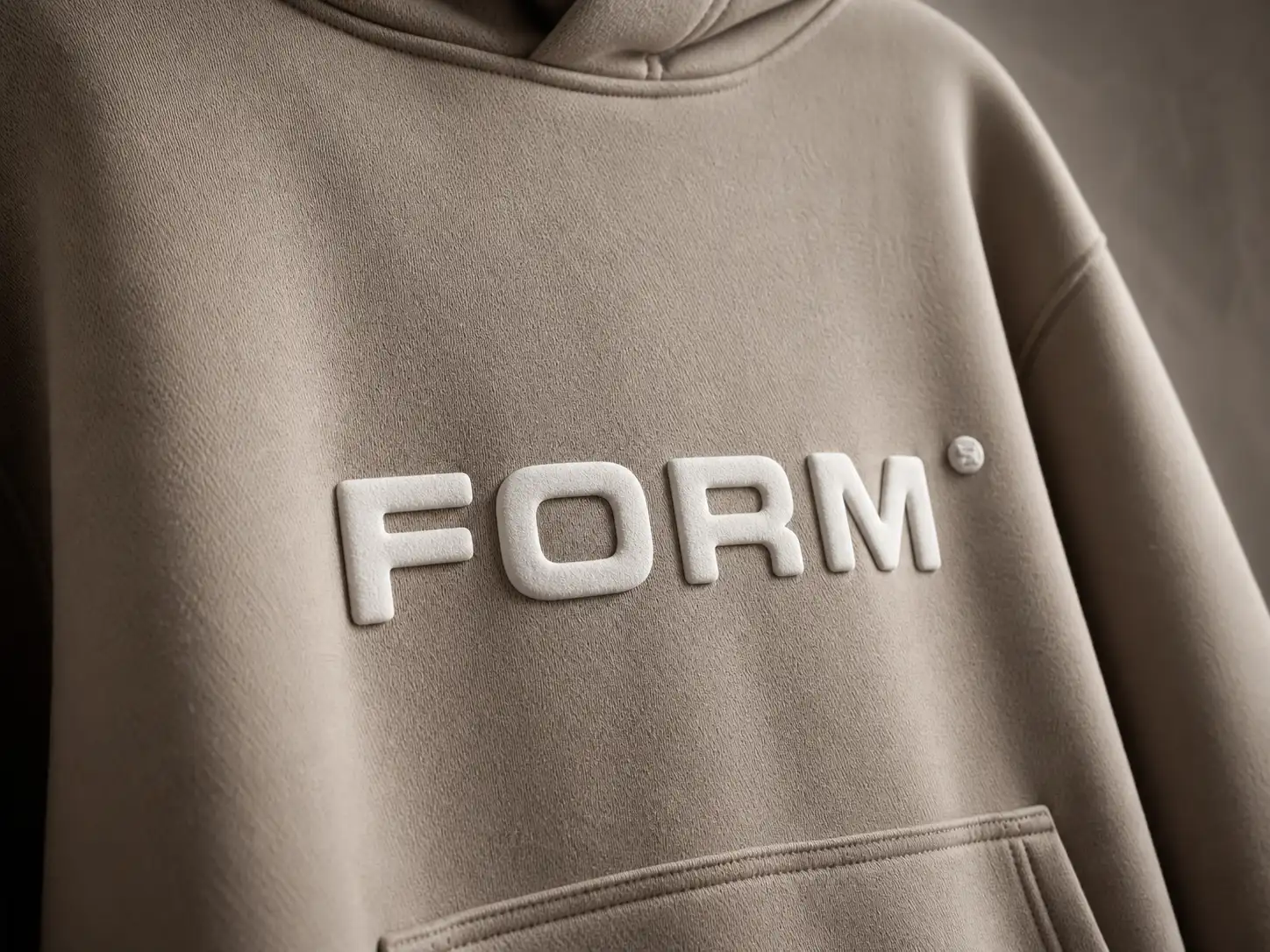 Beige hoodie with "FORM" embossed in white letters on the chest, showcasing a minimalist and stylish design.