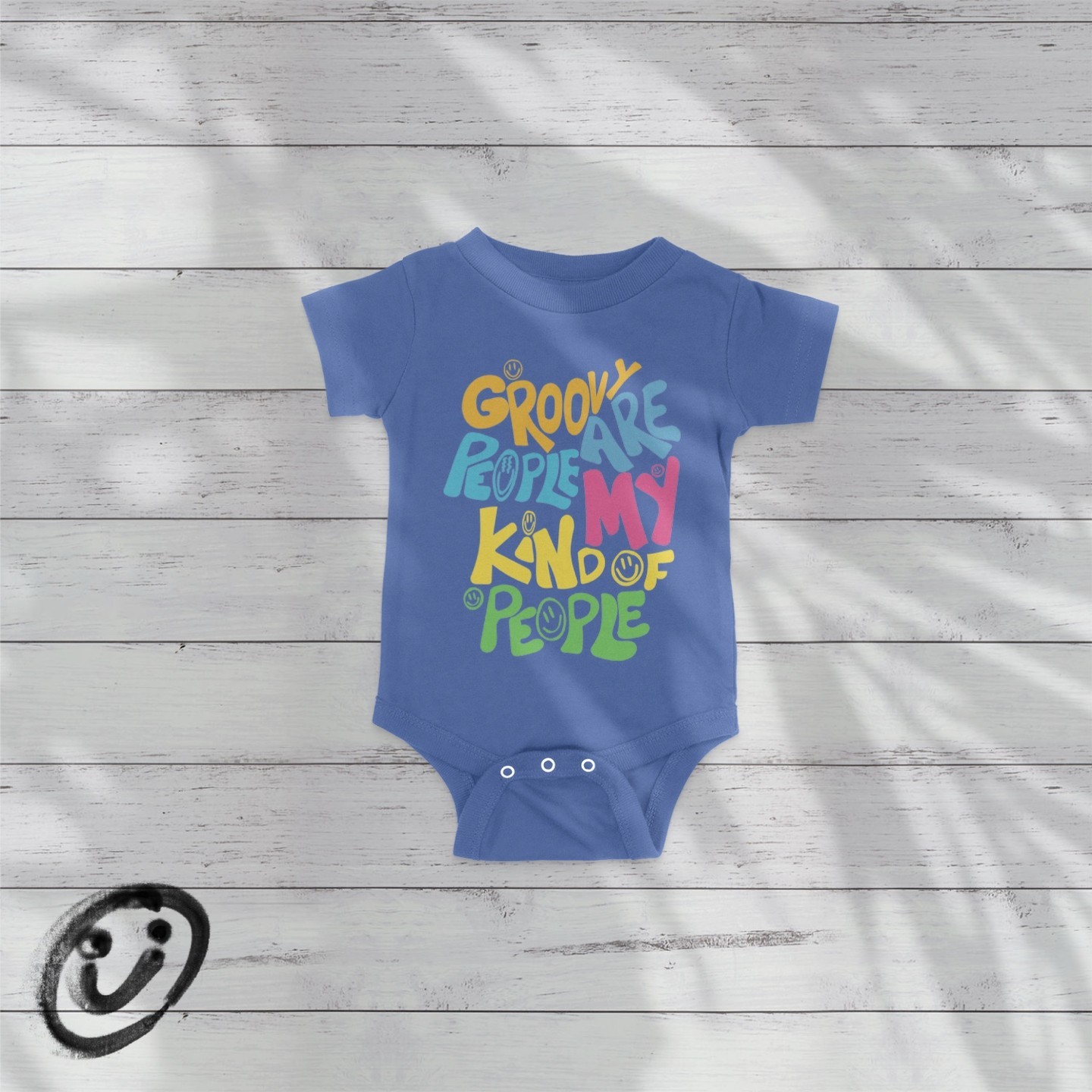 Blue baby onesie with groovy people smiley text on white background.